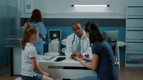 Doctor Consulting with Child and Mother in Office