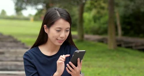 Woman use of mobile phone at outdoor park