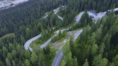 Aerial View of Winding Road in the Mountains and Green Forest