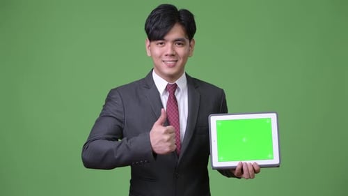 Young Adult Showing a Tablet with Green Screen