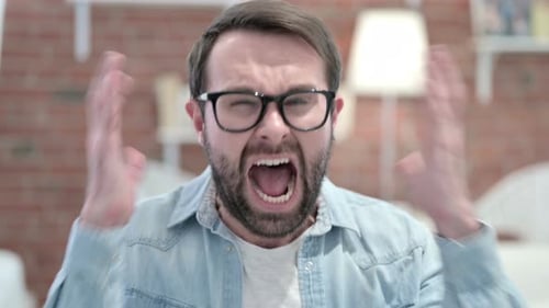 Portrait of Angry Beard Young Man Screaming in Loft Office