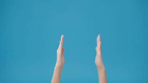 Young woman hand shows something amazing at blank space isolated over blue background in studio.