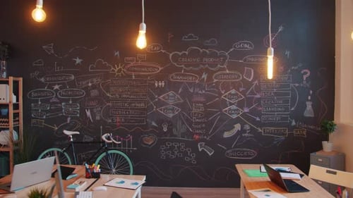 Tracking Shot of Stylish Creative Office Room with Chalkboard and Furniture Illuminated with Lamps