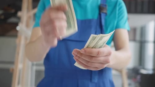 Closeup of Male Hands Counting Money Indoors