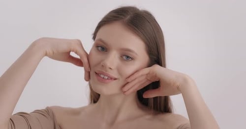 Young Woman Touching Her Face in a Studio
