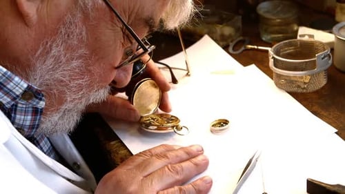 Watchmaker Inspecting Gold Pocket Watch Gears