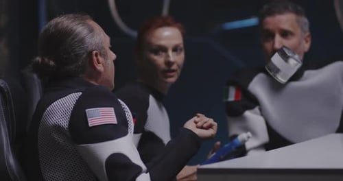 Adults in Spacesuits Examining Canned Food