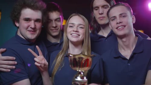 Smiling Team Poses with Prize Trophy