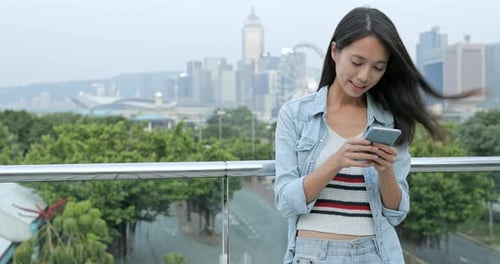 Woman using mobile phone in city
