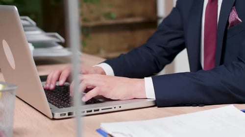 Dolly Nahaufnahme eines Unternehmensmitarbeiters beim Tippen auf dem Laptop
