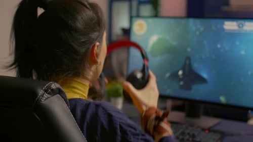 Woman Playing Space Action Video Game on Computer