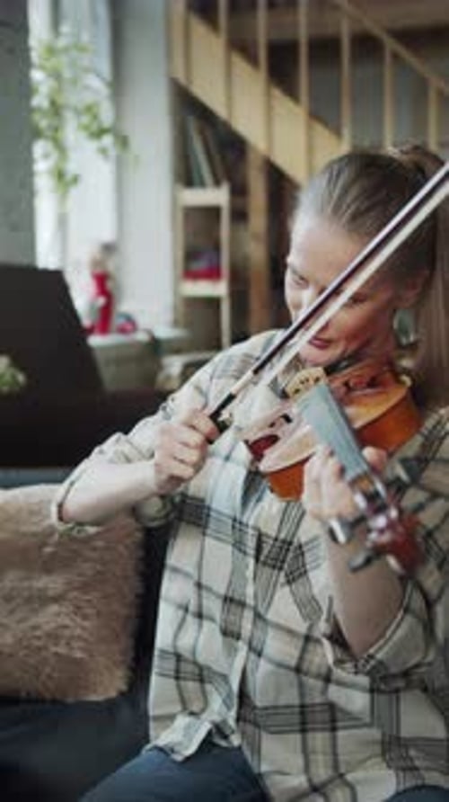 Woman Playing Violin for Child Inside Home