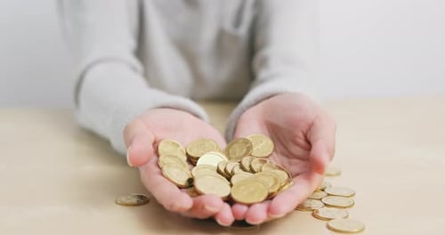 Hand Holding Gold Coins Close Up