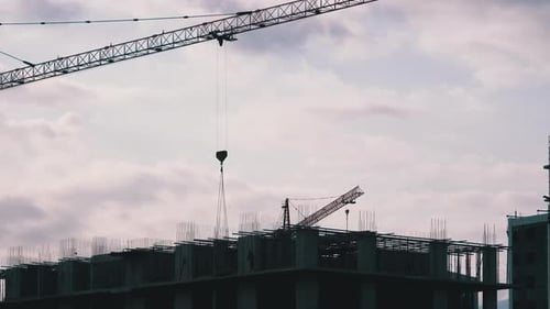 Turmdrehkran auf einer Baustelle hebt eine Last im Hochhaus