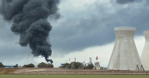 Unfall in der Ölraffinerie - riesige Explosionen und Feuerbälle steigen auf. Dicker schwarzer Rauch bedeckt den Himmel.