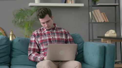 Mann mit Laptop macht Nickerchen auf dem Sofa