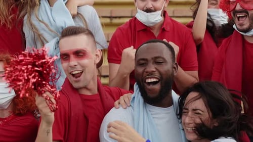 Group of People of Different Races Follow the Soccer Match in the Stands