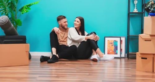 Cheerful Couple Relaxing in New Home After Moving
