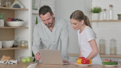 Couple Browsing Laptop Together in Bright Kitchen