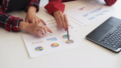 Team Discussing Graphs and Charts in Bright Office