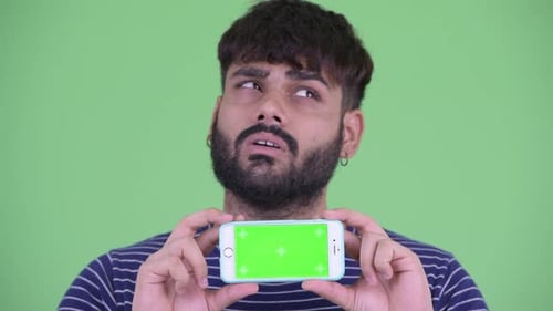 Young Adult Holds Smartphone with Green Screen