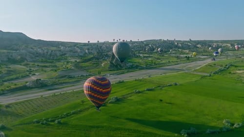 4K Aerial view of Goreme. Colorful hot air balloons fly over the valleys.