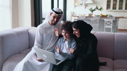 Middle Eastern Family Use Laptop Together At Home