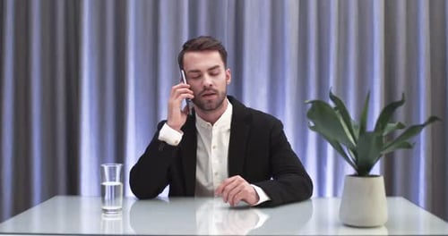 Man on Phone in front of Curtains