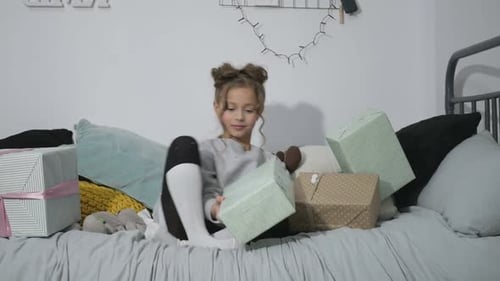 Girl Holding Gifts on Bed at Home