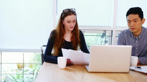 Young Adults Meeting at a Table in a Bright Office