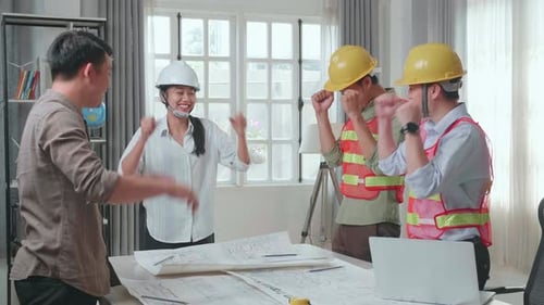 Engineers With Helmets And A Man Celebrating Finish Drawing Building Construction While Working
