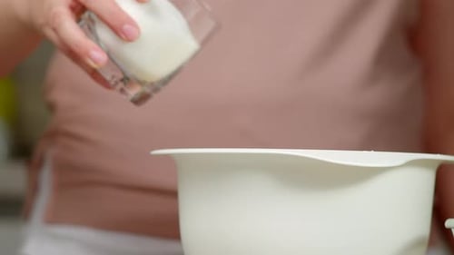 Baker Pours Sugar From Glass