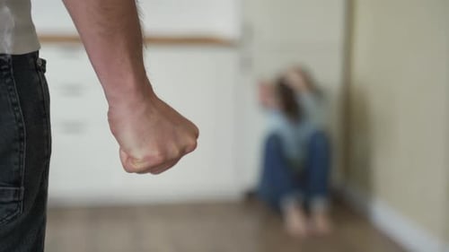 Clenched Fist Threatens a Distraught Woman