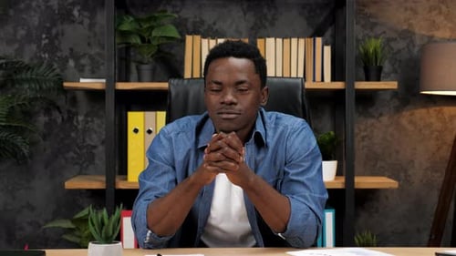 Man Sits At Desk In Modern Office Environment