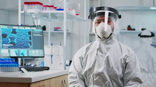 Scientist in Hazmat Suit Sitting in Laboratory