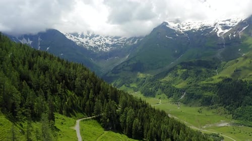 Beautiful Scenic Green Valley Surrounded By Alps Snowy Mountains Range on Summer Day Landscape