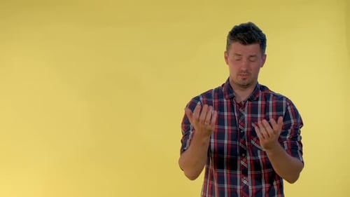 Confused man with crossed arms on yellow background