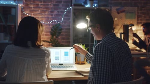 Man and Woman Smartphone App Designers Talking in Office Working with Laptop