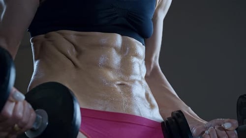 Defined Abdominal Muscles During Dumbbell Workout