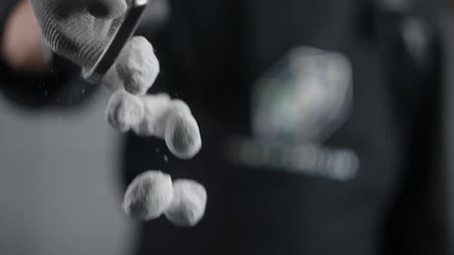 White Balls Sifting Through Metal Sieve Slow Motion