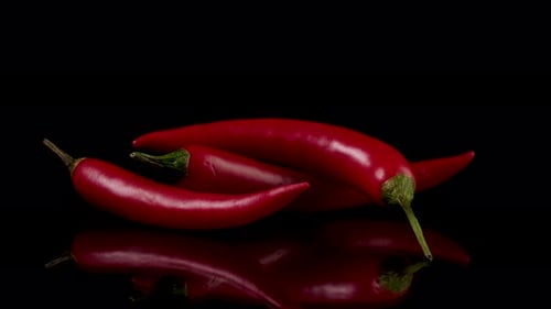 Red Chili Peppers with Fire on Black Background