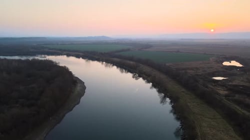 Aerial View of Wide River Flowing Quietly in Rural Countryside in Autumn Evening