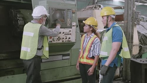 Group of engineer talking and training working using machine control together in industrial factory.