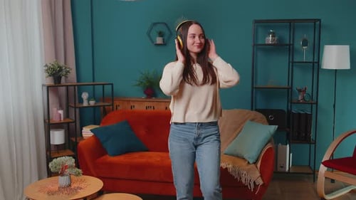 Happy Woman Dances in Living Room with Headphones