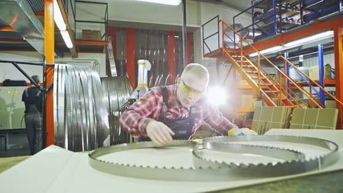 Industrial Worker Checks Metal Saw Blades in Factory