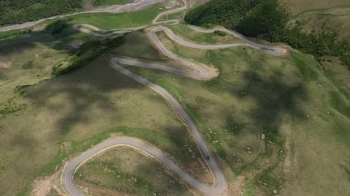 Cars passing through curve in mountainous road. Mountain serpentine road