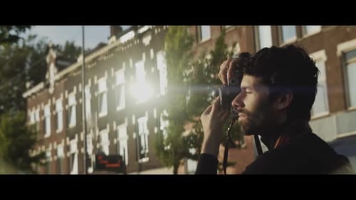 Man Photographs Buildings on Sunny City Day