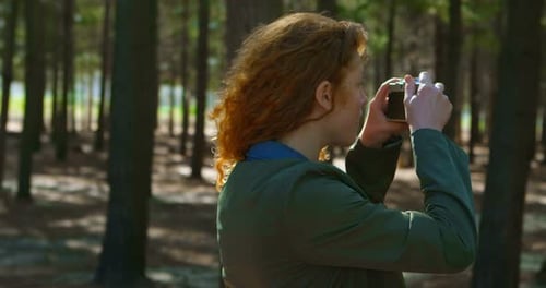 Woman Takes Photos in Sunny Forest