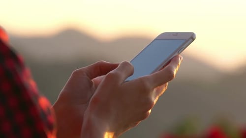 Woman Using Smartphone at Sunrise
