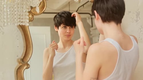 Woman Styling Short Hair in Elegant Mirror
